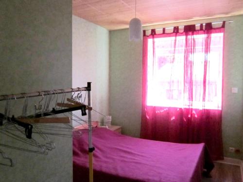 a bedroom with a pink curtain and a window at Maison avec spa à They-Sous-Montfort, accueillant et moderne in They-sous-Montfort