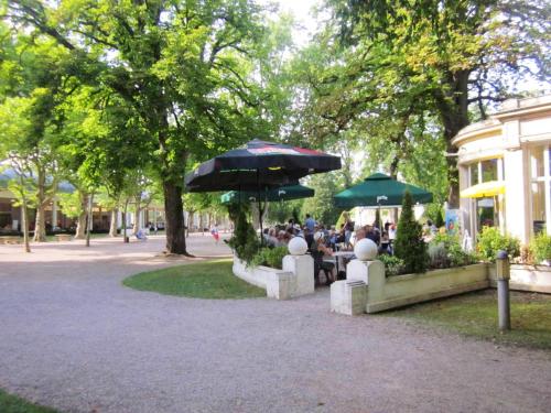a group of people sitting at tables under umbrellas at Maison avec spa à They-Sous-Montfort, accueillant et moderne in They-sous-Montfort