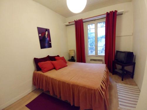 モントルイユにあるMaison d'une chambre avec jardin clos et wifi a Montreuilのベッドルーム1室(赤い枕のベッド1台、窓付)