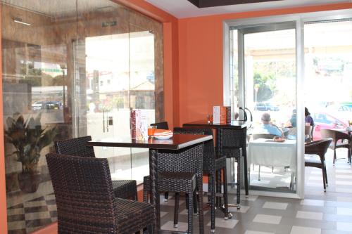 a restaurant with orange walls and tables and chairs at Hotel Carmen in La Cala de Mijas