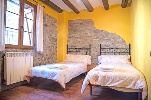 - 2 lits dans une chambre dotée de murs et de fenêtres jaunes dans l'établissement 2 bedrooms house with balcony and wifi at Belsierre, à Belsierre