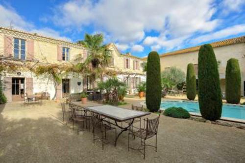 une table et des chaises devant une maison dans l'établissement Villa spacieuse et charmante à Saint-Gilles avec piscine privée, à Saint-Gilles