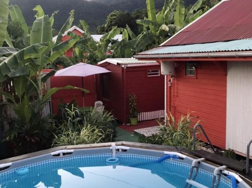 una casa con piscina al lado de un edificio rojo en Bungalow charmant à Trois-Rivières avec piscine privée, en Trois-Rivières