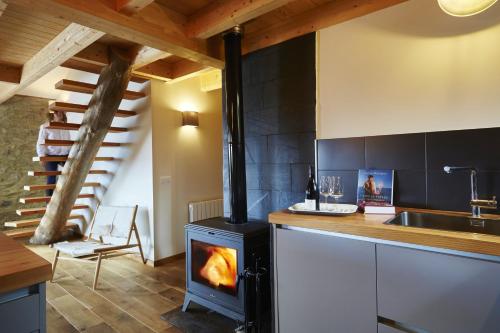 - une cuisine avec un poêle à bois dans l'établissement Maison spacieuse à La Llagonne avec vue montagne, à La Llagonne