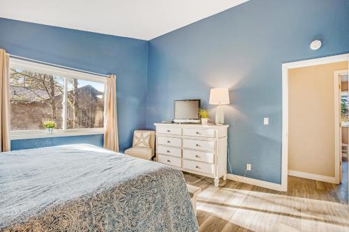 a blue bedroom with a bed and a window at WindWard Dream Vacation Home in Manzanita
