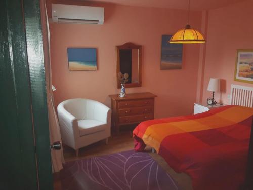 a bedroom with a bed and a chair and a mirror at Modern Apartment in Matalascañas with Shared Pool in Matalascañas