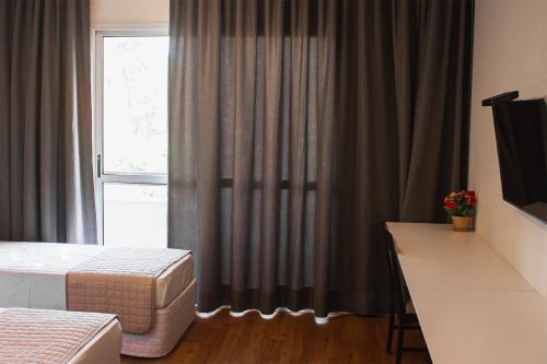 a hotel room with a bed and a window at Vip Hotel in Jaú