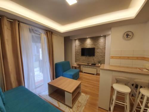 - un salon avec un canapé bleu et une table dans l'établissement Zora Apartman Zlatibor, à Zlatibor