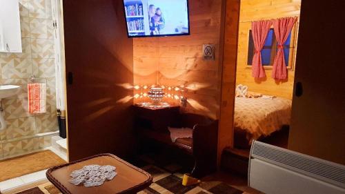 a bedroom with a bed and a tv on the wall at Etno selo EDEN in Žeravački Potok