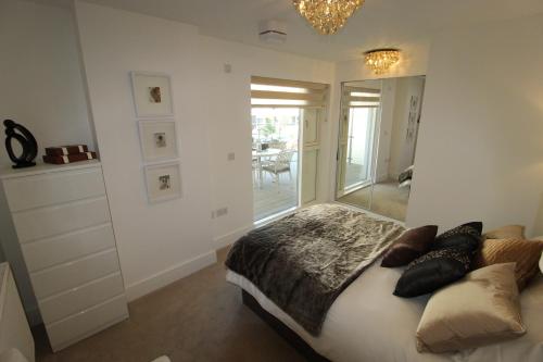 a bedroom with a bed and a large window at East Coast - Beautiful and modern holiday home in Bournemouth