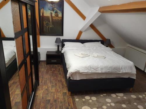a bedroom with a bed with white sheets at Apartament Roma in Braşov