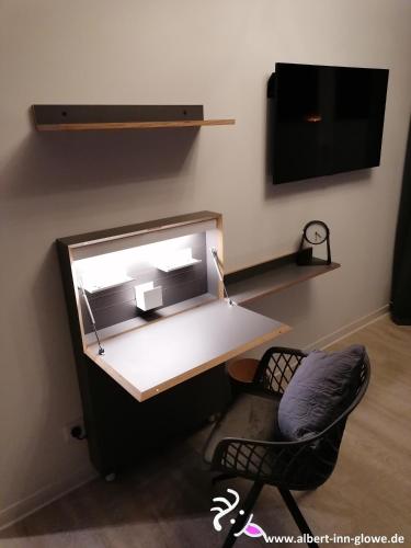 a desk in a room with a chair and a tv at Albert-INN-Glowe - barrierefrei & 3 Schlafzimmer & Coworking & Strandkorb-saisonal & Sauna im Haus & Fahrräder in Glowe