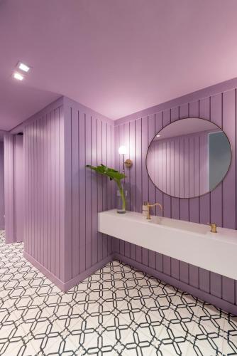 a purple bathroom with a sink and a mirror at CasaSur Palermo Hotel in Buenos Aires