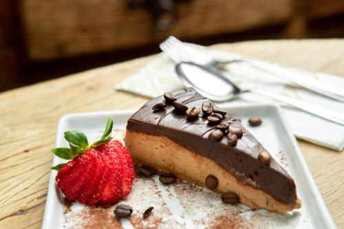 a piece of chocolate cake and a strawberry on a plate at Hotel Fazenda Dona Carolina in Itatiba