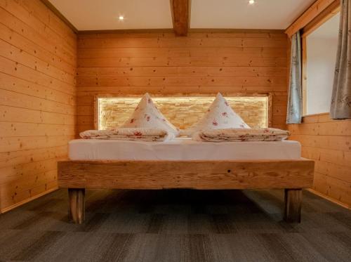 Cama en habitación de madera con ventana en Ferienwohnung Hallweger, en Ruhpolding