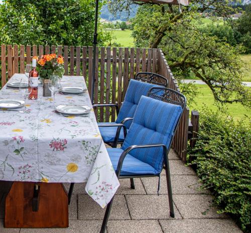 uma mesa com duas cadeiras azuis sentadas num pátio em Ferienwohnung Hallweger em Ruhpolding