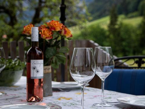 una botella de vino sentada en una mesa con dos copas de vino en Ferienwohnung Hallweger, en Ruhpolding