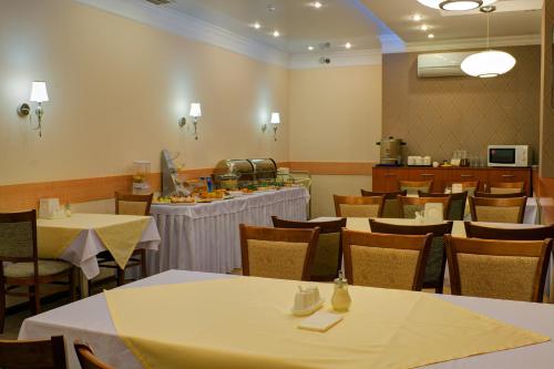 a dining room with tables and chairs and a counter at Torgay Hotel in Astana