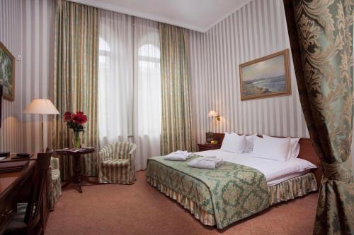 a hotel room with a large bed and a desk at Hotel Otrada in Odesa