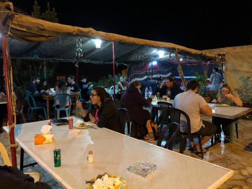 um grupo de pessoas sentadas em mesas sob uma tenda em Al Midan Hotel em Amã