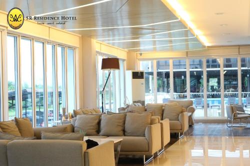 a waiting room with couches and chairs in a building at SR Residence Hotel in Phetchabun