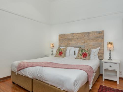 a bedroom with a large bed with a wooden headboard at Abbotts Hill in Malmesbury