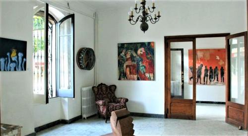 a living room with a chandelier and a chair in a room at Hostal Montsoliu in Arbúcies