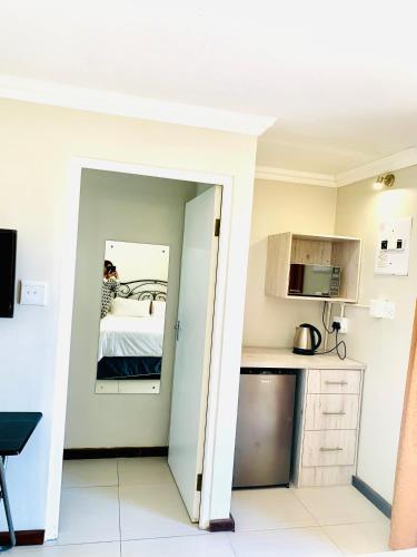 a kitchen with a door leading into a room at Stay at 11 on Gull in Cape Town