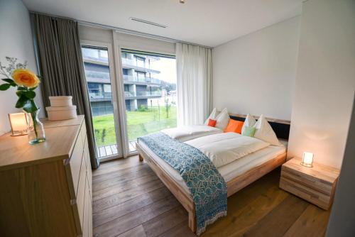 a bedroom with a bed and a large window at Eden Mountain Resort - Duke in Arosa