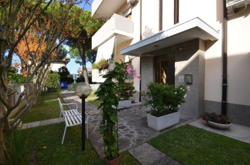 a house with a white chair and some plants at Villa Lucia in Lignano Sabbiadoro