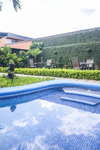 a swimming pool with a view of a resort at Berlor Airport Inn in Alajuela City