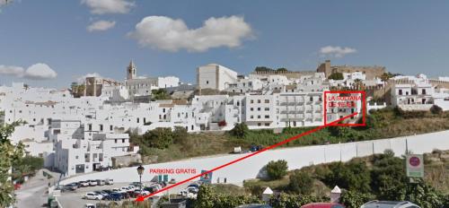 a city with white buildings on a hill with a red sign at La Sultana de Vejer in Vejer de la Frontera