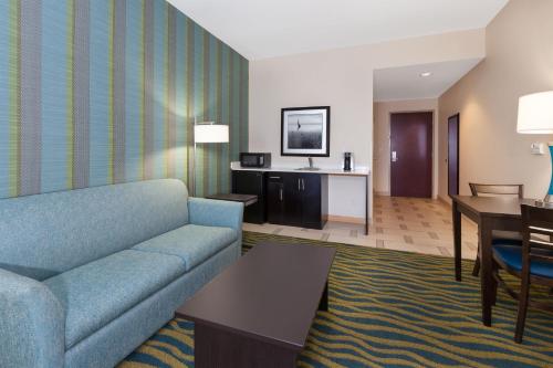 a living room with a couch and a table at Holiday Inn Express & Suites Southport - Oak Island Area by IHG in Oak Island