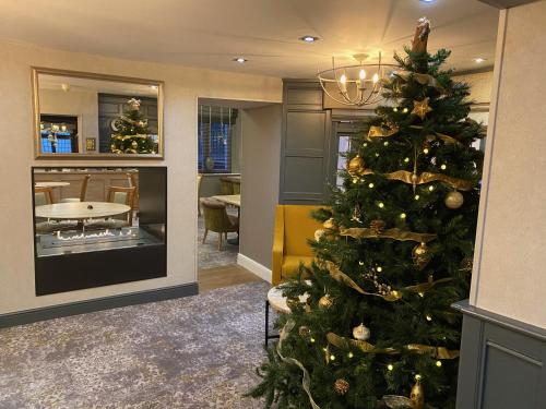 uma árvore de Natal numa sala com uma sala de jantar em The Malvern Hills Hotel em Great Malvern