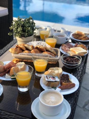 een dienblad met ontbijtproducten en drankjes op een tafel bij Hôtel Le Mas Des Amandiers in Graveson
