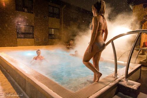 a woman is standing in a swimming pool at Hotel V in Gatineau