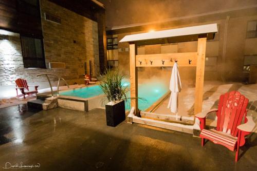 a swimming pool with a bed and two chairs at Hotel V in Gatineau