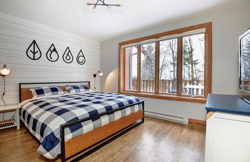 a bedroom with a bed and a large window at Chalets Alpins- 4 Chemin des Montagnards in Stoneham