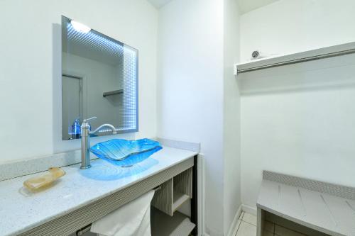 La salle de bains est pourvue d'un lavabo et d'un miroir. dans l'établissement The Freeport Inn and Marina, à Freeport
