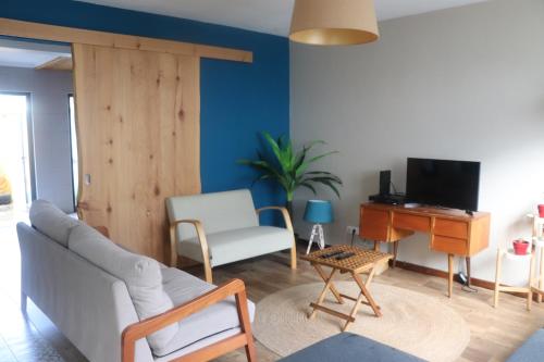 a living room with a couch and a television at Porto Pim Guest House in Horta