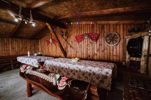 Habitación con 2 mesas en una cabaña de madera en Piatra Rancii en Ranca