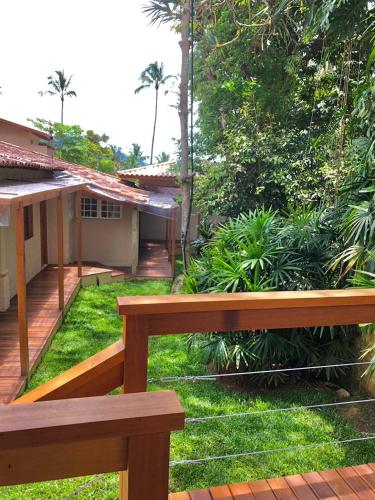a wooden bench in front of a house at La Bella Suítes in Ilhabela