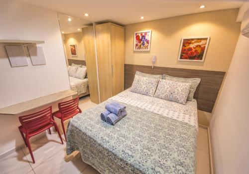 niewielka sypialnia z łóżkiem i 2 krzesłami w obiekcie ISRAEL TAMBAU Flat by PenareiaTurBr w mieście João Pessoa