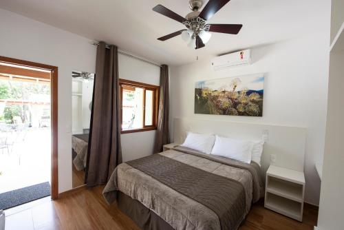 um quarto com uma cama e uma ventoinha de tecto em Pousada Cantuá em Serra do Cipó