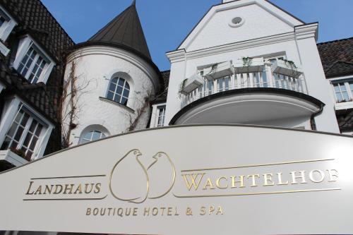 a sign for the wolfgang boutique hotel and spa in front of a building at Hotel Landhaus Wachtelhof in Rotenburg an der Wümme