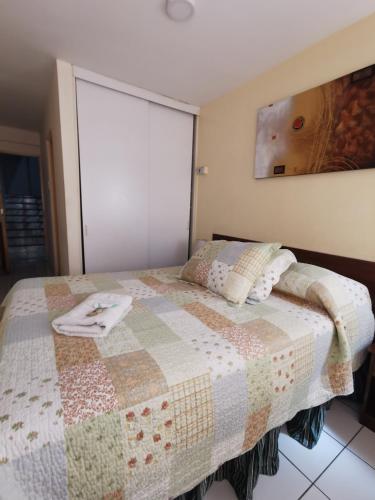 a bedroom with a bed with a quilt on it at Hotel Plaza Colon in Arica