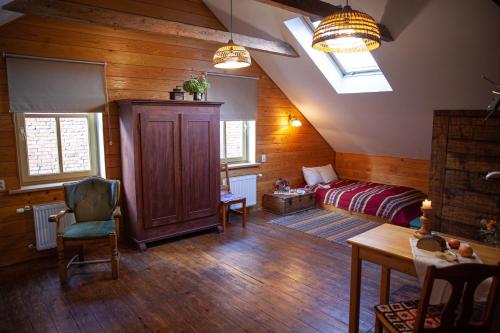 a attic room with a bed and a table and chairs at Ezera Maja in Liepāja