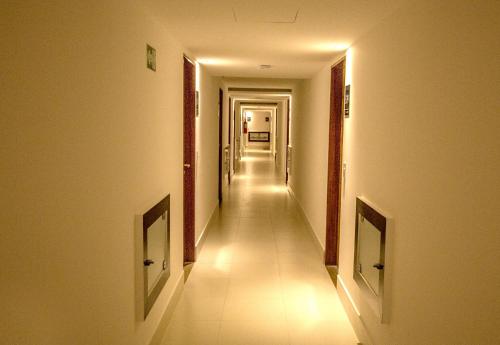 a hallway with a long corridor with white walls and lights at GOLDFLAT Cabo Branco by PenareiaTurBr in João Pessoa