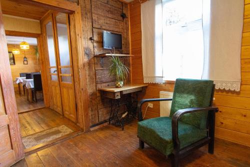 a room with a chair and a desk and a television at Ezera Maja in Liepāja