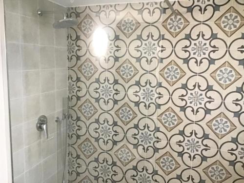 uma casa de banho com um chuveiro e uma parede em azulejo em GoodStay Dimora San Lazzaro em Lecce